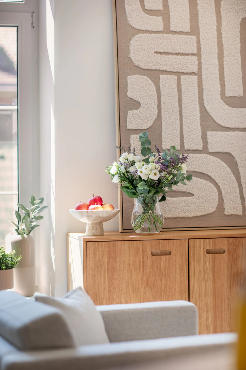 Sideboard mit Blumen in den Räumlichkeiten von Nina Haberlehner