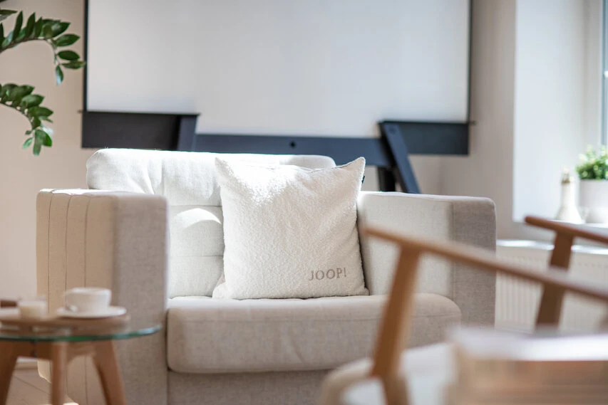 Eine Couch mit Pölstern im Bild