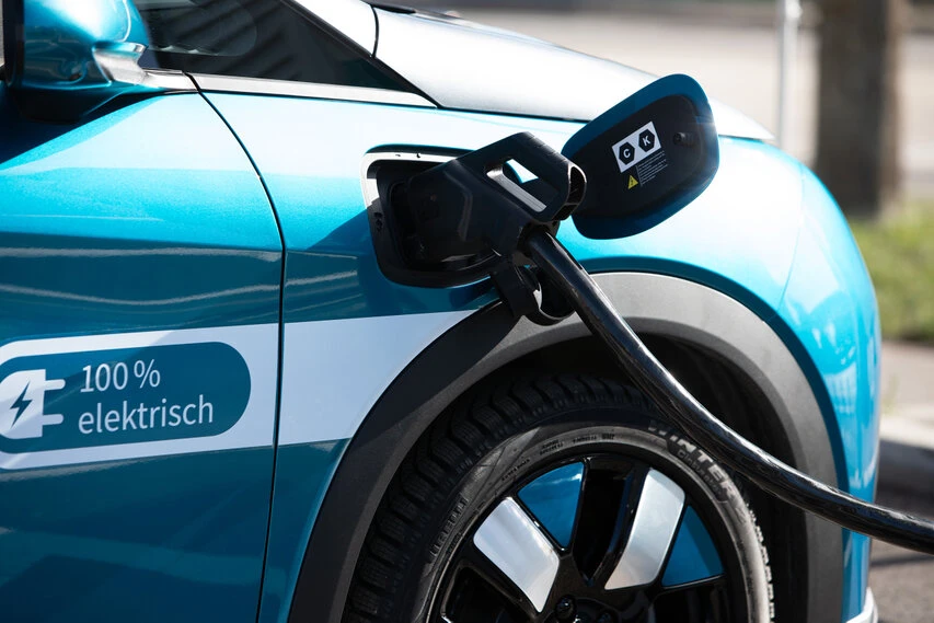 Ein Elektrofahrzeug bezieht über einen Stecker Strom.