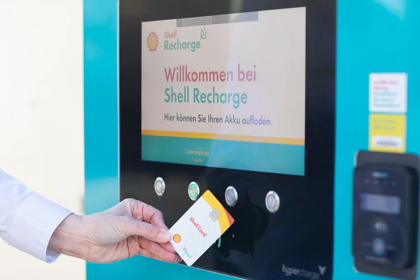 Ladestation von Shell zum Laden eines Elektrofahrzeugs. Die NFC-Ladekarte wird angehalten.
