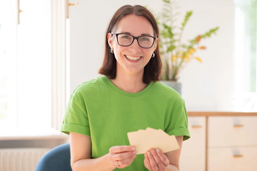 Psychologin Karin Andre sitzend mit Karten für eine Therapiesitzung in der Hand